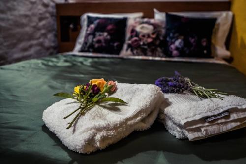 een bed met twee handdoeken en bloemen erop bij Montanhas do Xisto - Casa da Eira in Candal