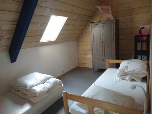 a attic room with two beds and a skylight at Le panoramique in Campan