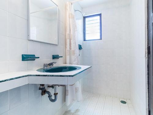 a white bathroom with a sink and a mirror at Hotel Villa Real II in San Crist&oacute;bal de Las Casas