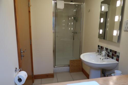 a bathroom with a sink and a shower at Corunna Cottage in Inverness