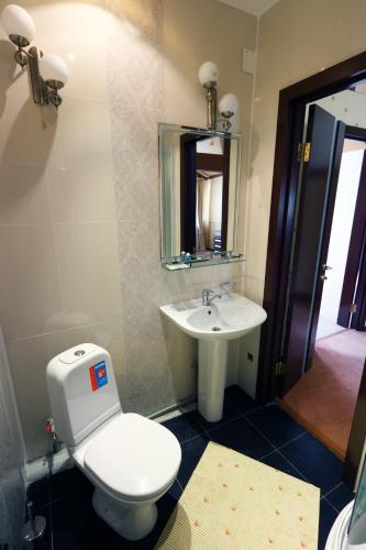 a bathroom with a toilet and a sink at Alpen Ville in Almaty