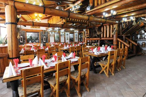 un restaurante con mesas de madera y sillas con servilletas. en Gura Diham en Buşteni