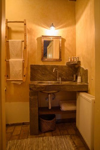 a bathroom with a sink and a mirror and towels at Oikies Katogi in Pramanta