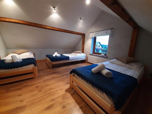 a bedroom with two beds and a window at Zielona Mila Dom Wakacyjny in Cekcyn