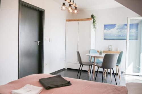 a bedroom with a table and chairs and a dining room at Balkon Apartmanház Panzió in Balatonfüred