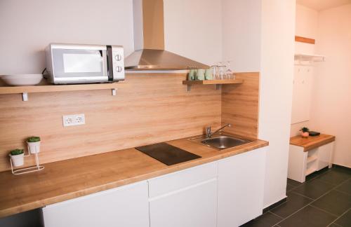 a kitchen with a sink and a microwave at Balkon Apartmanház Panzió in Balatonfüred