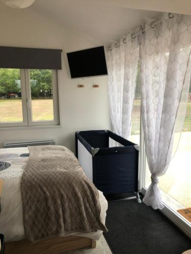 a bedroom with a bed and a large window at Studio Au numéro 10, proche zoo de Beauval et sortie d autoroute in Villefranche
