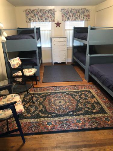 a room with two bunk beds and a rug at Snowchasers Lodge in Lincoln
