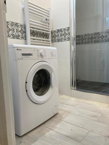 a washing machine in a bathroom with a shower at Le Jeanne d'Arc - Appartements meublés in Gien