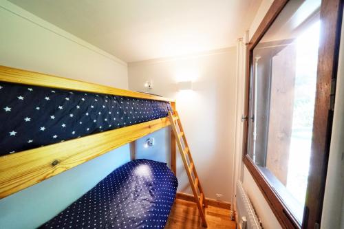 a bunk bed in a room with a window at La Ménandière in Megève