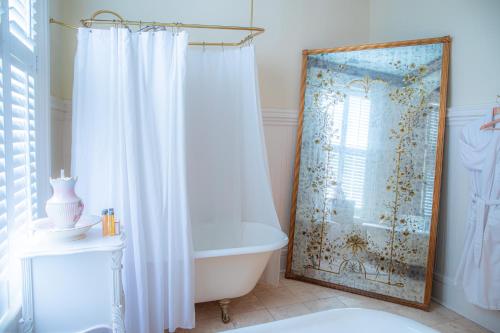 uma casa de banho com uma banheira e uma cortina de chuveiro em Justine Inn Savannah em Savannah