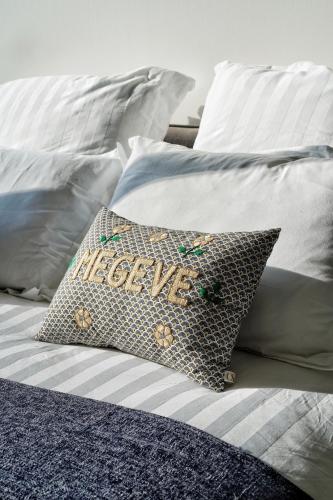 a bed with a pillow with the word welcome at La Ménandière in Megève