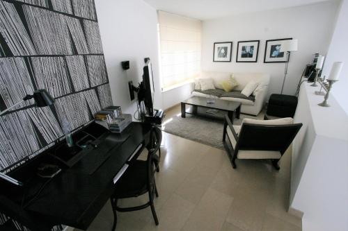 Casa Ameixeira في فيريغودو: غرفة معيشة مع مكتب وأريكة