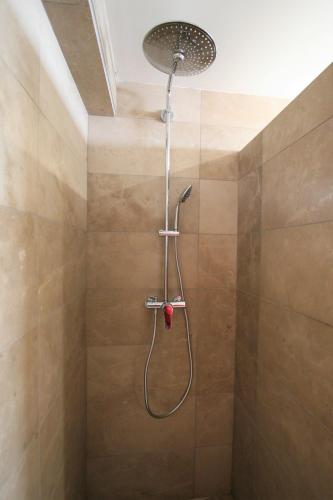 a shower with a shower head in a bathroom at Casa Ameixeira in Ferragudo