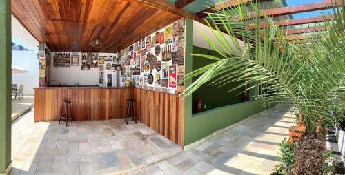 a restaurant with a counter and a palm tree at Hotel Cajueiro Guarujá in Guarujá