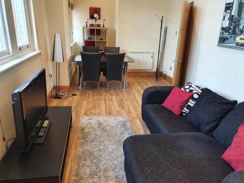 uma sala de estar com um sofá e uma mesa com cadeiras em Marina Court LA14 2HL em Barrow in Furness