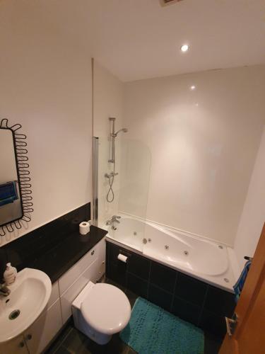 a bathroom with a tub and a toilet and a sink at Marina Court LA14 2HL in Barrow in Furness
