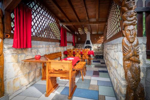 a restaurant with wooden tables and chairs and red curtains at Pension Eric in Ostrov