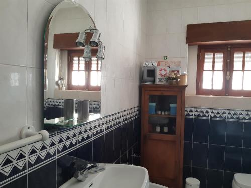 a bathroom with a sink and a mirror and a toilet at Casal do Morgado, country house to relax in Formigais