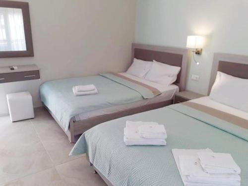 a hotel room with two beds with towels on them at Villa Lemar in Sarti