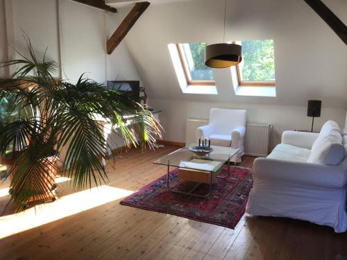 a living room with two white couches and a table at FeWo Spitzweg, Garlstorf - Lüneburger Heide in Garlstorf