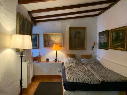 2 Betten in einem Zimmer mit einer Lampe und Gemälden in der Unterkunft El sosiego, der Rückzugsort in Santa Brígida