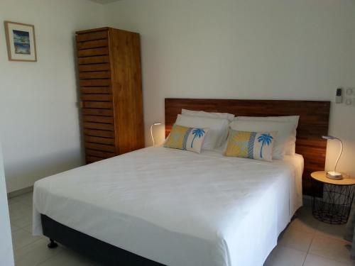 a bedroom with a large bed with white sheets and pillows at SNP- PALMS in Papetoai