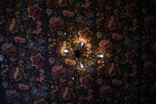 a chandelier hanging from a ceiling with flowers at The Dairy Hotel Queenstown, A Naumi Chapter in Queenstown