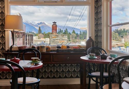 皇后鎮的住宿－The Dairy Private Hotel by Naumi Hotels，客房设有两张桌子和一个享有美景的窗户。
