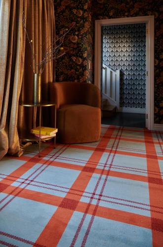 a living room with a couch and a rug at The Dairy Hotel Queenstown, A Naumi Chapter in Queenstown