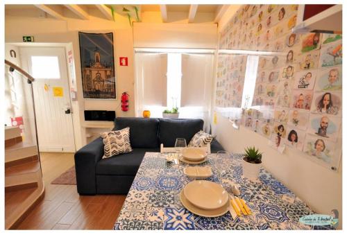 uma sala de estar com uma mesa e um sofá em Casinha da Ti Babel em Faro