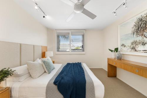 a bedroom with a bed and a ceiling fan at Fairshore 22 Main Beach Views in Noosa Heads