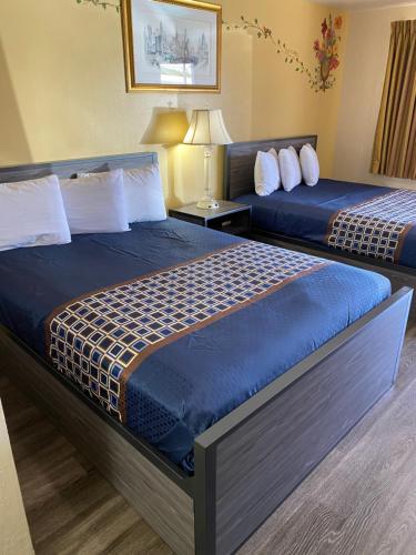 una habitación de hotel con 2 camas y una lámpara en Americas Best Value Inn - Legend's Inn, en Junction