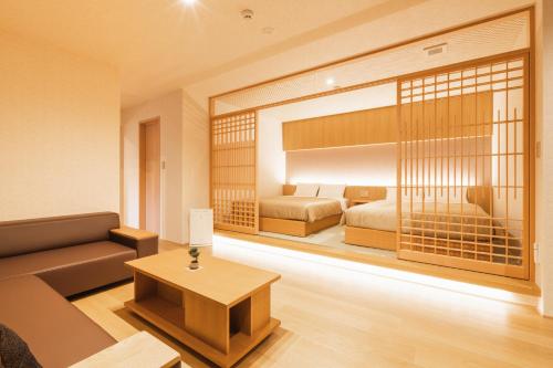 a living room with two beds and a couch at GRAND BASE Hakata Gofuku in Fukuoka