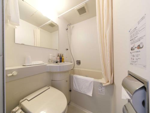 małą łazienkę z toaletą i umywalką w obiekcie Meitetsu Inn Nagoya Nishiki w mieście Nagoja