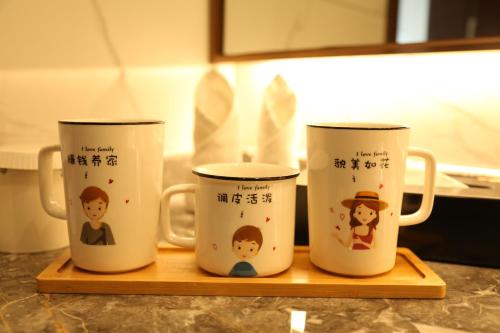 three coffee mugs sitting on a wooden tray at Guangdong Yingbin Hotel in Guangzhou