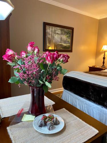 a vase of pink flowers on a table in a room at Grafton Lodge in Lake Lure