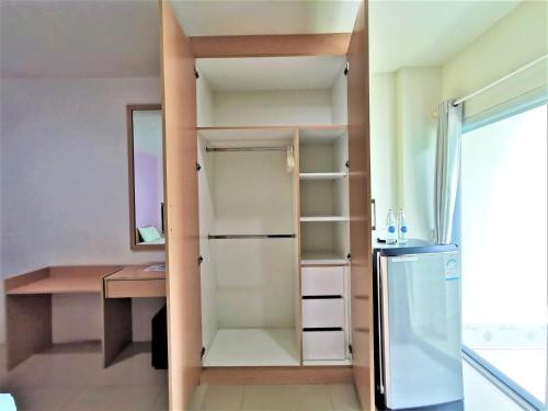 a small kitchen with a refrigerator and a mirror at Hua Hin Irooms in Hua Hin