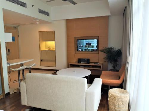 a living room with a white couch and a table at Cormar Suites in Kuala Lumpur