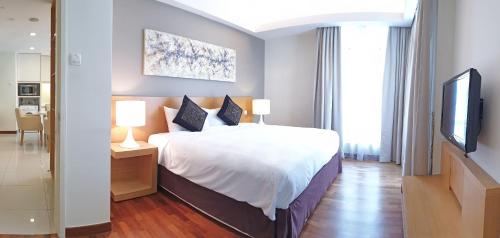 - une chambre avec un grand lit et une télévision dans l'établissement Cormar Suites, à Kuala Lumpur