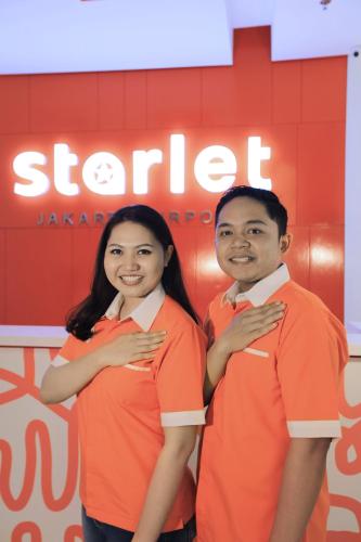 a man and a woman dressed in orange shirts at Starlet Hotel Jakarta Airport in Tangerang
