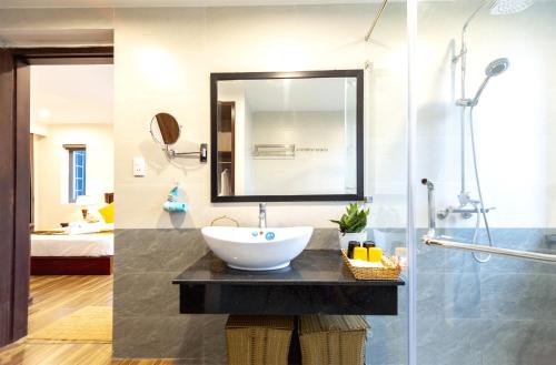 a bathroom with a sink and a shower at SHALA BOUTIQUE HOIAN in An Bang