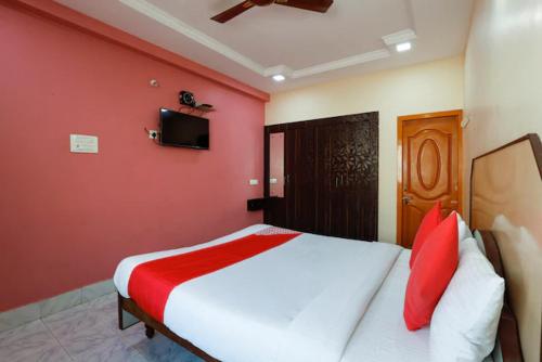 a bedroom with a large bed with red walls at Jaya Krishna Mansions in Vellore