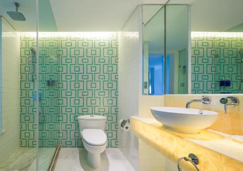 a bathroom with a sink and a toilet and a shower at Dorsett Shanghai in Shanghai