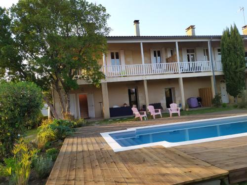 una casa con una piscina di fronte di L Atelier Demoiselle a Cadillac