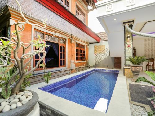 a swimming pool in the courtyard of a house at OYO 4003 Ceria Guesthouse Seminyak in Seminyak