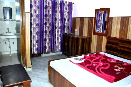 um quarto com uma cama grande e cortinas roxas em Mother Palace em Nova Deli