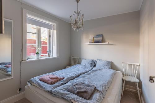 1 dormitorio con cama, ventana y lámpara de araña en Stockholm Archipelago apartment, en Vaxholm