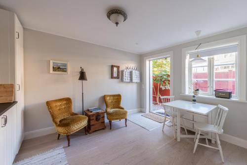 uma sala de estar com uma mesa e cadeiras brancas e uma janela em Stockholm Archipelago apartment em Vaxholm