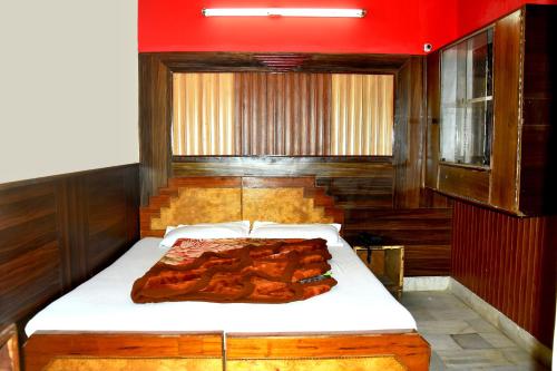 Ce lit se trouve dans une chambre dotée d'un mur rouge. dans l'établissement Mother Palace, à New Delhi